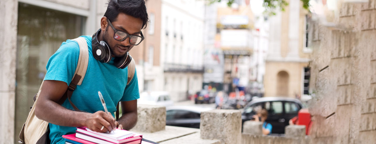 Boy writing on a notebook with pen